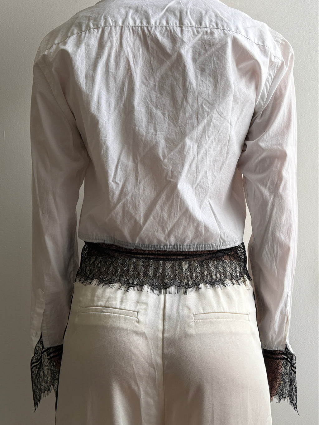 White top with black lace trim on a white background
