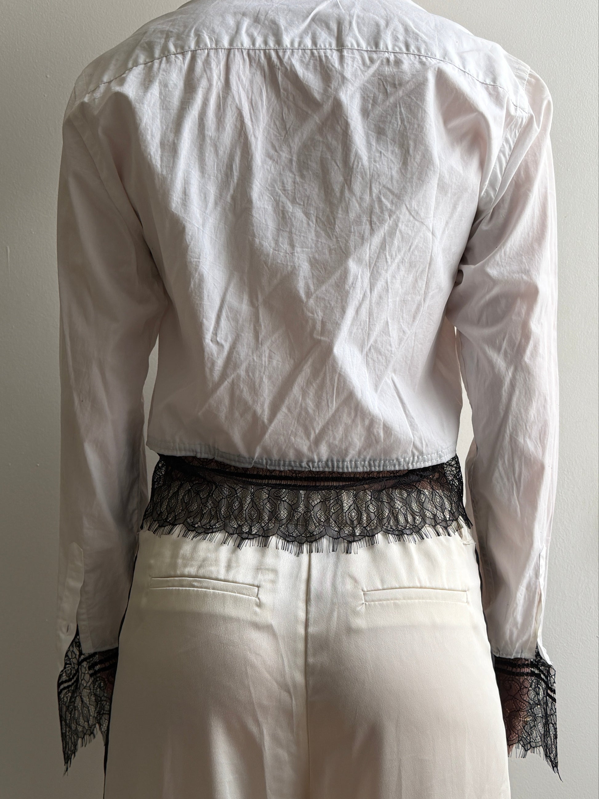 White top with black lace trim on a white background