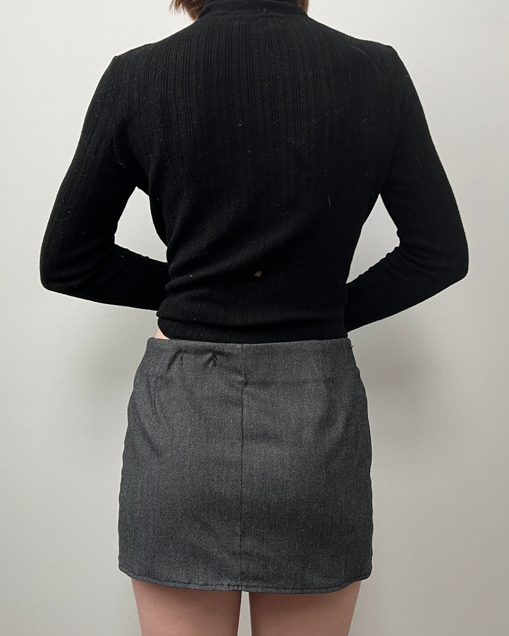 Female wearing a dark gray mini skirt.