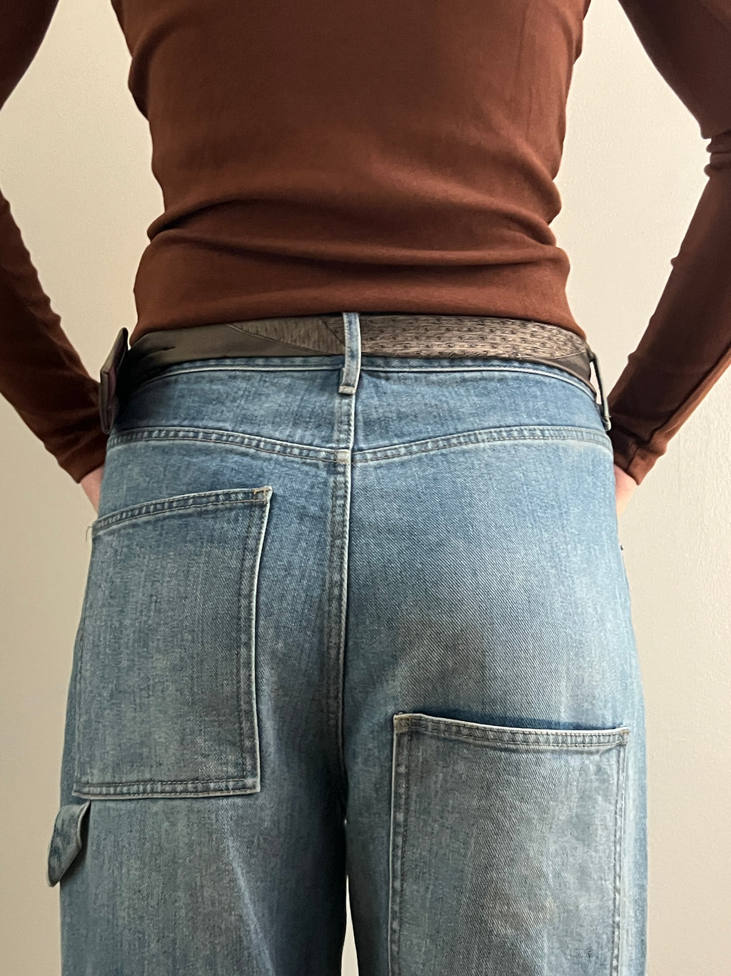 Person wearing blue jeans with a plain background