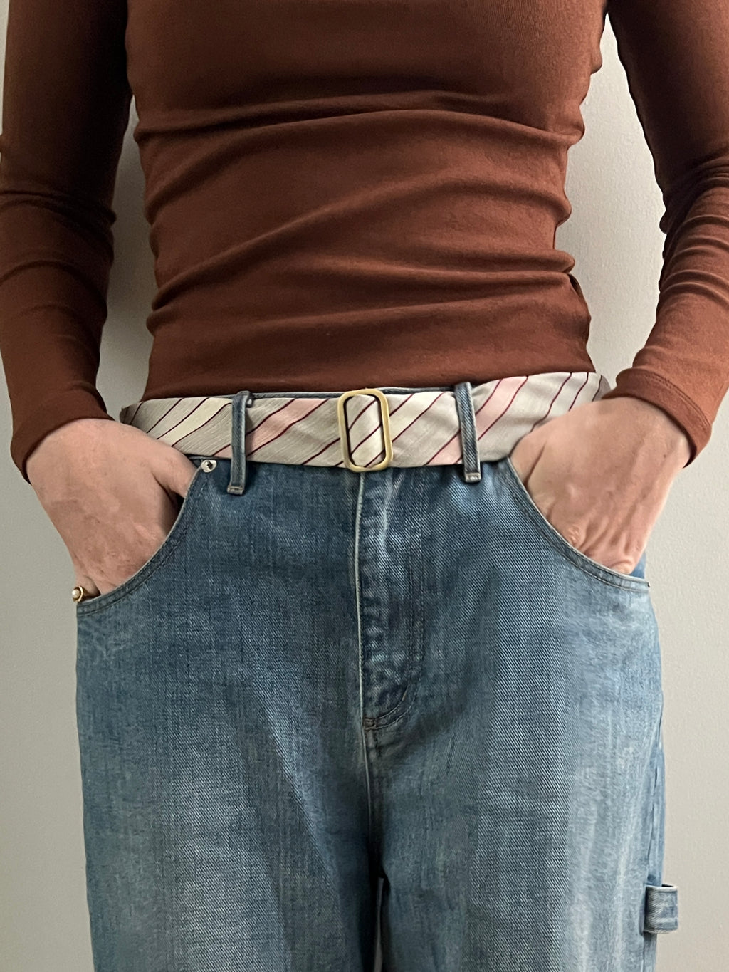 Person wearing belt on beige background